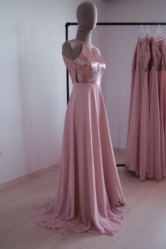 the dress is on display in front of two mannequins wearing pink dresses