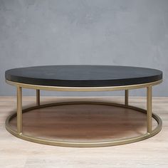 a black and gold coffee table sitting on top of a wooden floor