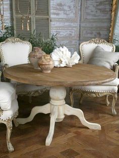 a round wooden table with white chairs around it