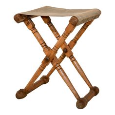 a small wooden stool with wheels on it's legs and seat cushion in the shape of an x