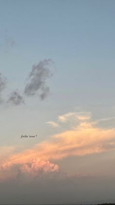 an airplane is flying high in the sky at sunset with clouds and trees below it