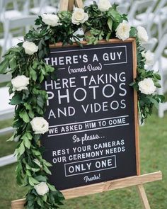 a sign with flowers on it that says there's a guy here taking photos and videos