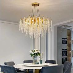 a dining room table with blue chairs and a chandelier hanging from the ceiling