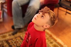 a young boy sitting on the floor looking up