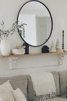 a living room filled with furniture and a round mirror