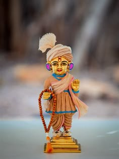 a small figurine is standing on a wooden stand with beads in his hands