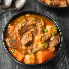 two black bowls filled with stew and vegetables