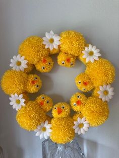 a group of yellow chicks sitting on top of a glass vase filled with white flowers