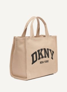 Adjustable crossbody strap Top handle DKNY logo at front Zip closure Origins: Imported Style: R41AOR57 | DKNY Hadlee Medium Tote in Beige Dkny Logo, Medium Tote, Strap Top, Strap Tops, Crossbody Strap, Top Handle, ? Logo