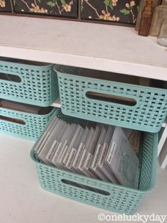 baskets are stacked on top of each other in front of a white table with drawers