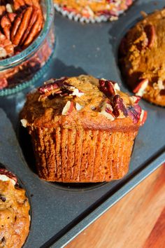 several muffins with pecans and cranberries in them on a tray