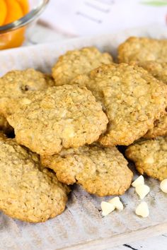 some cookies are sitting on top of a paper towel next to an orange and glass bowl