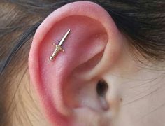 a close up of a person's ear with a pair of scissors in it