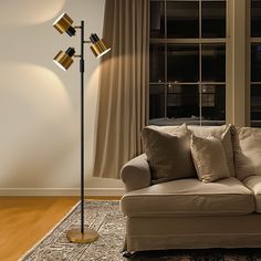 a living room scene with focus on the couch and floor lamp in the foreground