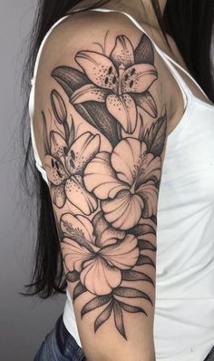 a woman's arm with flowers and leaves on the back of her shoulder, in black and white