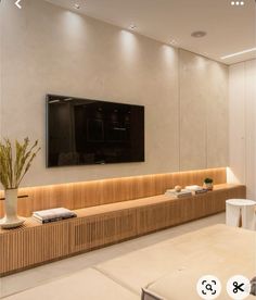 a large flat screen tv mounted to the side of a wall in a living room