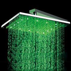 a shower head with green water running down it's side and the light is on