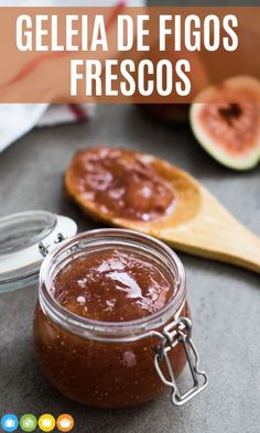 a jar filled with jam sitting on top of a table next to sliced figs