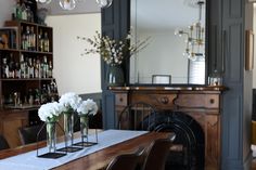 a dining room table with chairs and vases on it