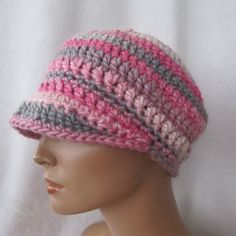 a mannequin head wearing a pink and gray crocheted hat