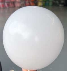 a person holding a white balloon in their hand