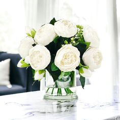 Discover the enchanting allure of our White Peony Small Size Arrangement - a captivating faux centerpiece that will elevate your home décor with its timeless elegance. Nestled in a sleek 4" tall glass vase, these small-head silk flowers showcase the perfect fusion of beauty and realism, adding a touch of sophistication to any space. Whether adorning your dining table, enhancing a wedding celebration, or gracing your living room, this floral centerpiece exudes a French country charm that compleme Peony Centerpiece, Tall Glass Vase, Pearl Centerpiece, Peony Arrangement, Wedding Floral Centerpieces, Pillows Flowers, Silk Flower Arrangements, Brown Silk, Artificial Roses