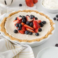 there is a pie with strawberries and blueberries on top