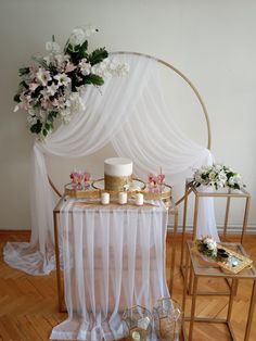 a table topped with a cake covered in frosting next to two small tables filled with cakes