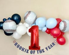 a number one balloon with baseballs and balloons around it