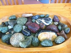 a bowl filled with rocks sitting on top of a wooden table