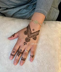 a woman's hand with henna tattoos on it