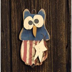 an owl made out of wood sitting on top of a wooden fence with stars and stripes