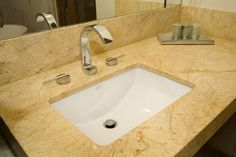 a bathroom sink sitting under a mirror next to a faucet