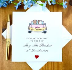 a wedding card with a couple kissing in the back of a car on top of a wooden table