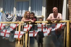 three people and two children standing on a balcony