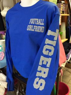 a blue shirt with the words football girlfriend on it in white letters and glitters