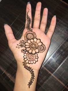 a woman's hand with henna tattoos on it