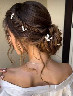 a woman with long hair and flowers in her hair is wearing a white dress, looking off to the side