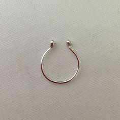 a pair of silver hoop earrings sitting on top of a white surface