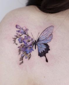 a woman's back shoulder with a butterfly and flowers tattoo on her left shoulder