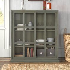 a green bookcase sitting on top of a hard wood floor next to a basket