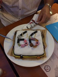 a man is cutting into a cake with scissors and other decorations on the plate next to him