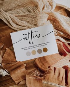 a white business card sitting on top of a pile of brown and beige fabric next to a pair of scissors