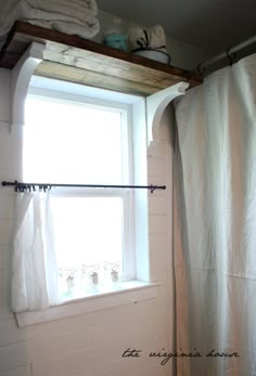 a bathroom with a window, shower curtain and toilet