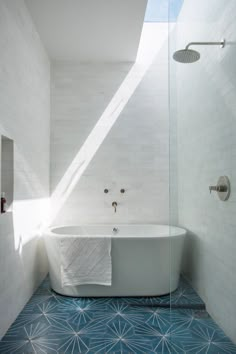 a white bath tub sitting in a bathroom next to a window