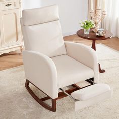 a white rocking chair sitting on top of a rug