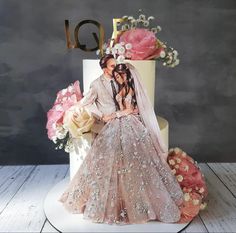 a wedding cake topper with the bride and groom on it, surrounded by flowers