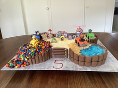 a birthday cake made to look like a train track with lots of toys on it