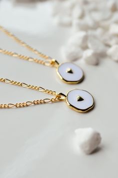 This is a new favorite minimal charm necklace. It's SO pretty. White charm with a gold heart in the middle, and it's hanging from our logan chain. Layer this up with a Luna necklace and you've got a really beautiful stack. Gold-filled is the closest alternative to solid gold. Gold filled jewelry has a thick layer of solid gold bonded onto the base layer, usually brass or sterling silver. Compared to gold plated which uses a process of electroplating that quickly dips your jewelry in gold, result White Clavicle Chain Necklace With Initial Pendant, White Initial Pendant Necklace With Clavicle Chain, White Initial Pendant Clavicle Necklace, White Clavicle Chain Necklace For Valentine's Day, Dainty White Heart Necklace With Delicate Chain, Minimalist Pendant Charm Necklace For Best Friend, Minimalist Charm Necklaces For Best Friend Gift, Minimalist Charm Necklace For Best Friend Gift, Minimalist Everyday Charm Necklace With Heart Charm