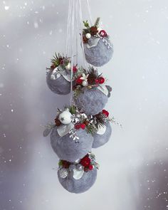 three ornaments hanging from strings in the air with snow flakes on them and evergreens